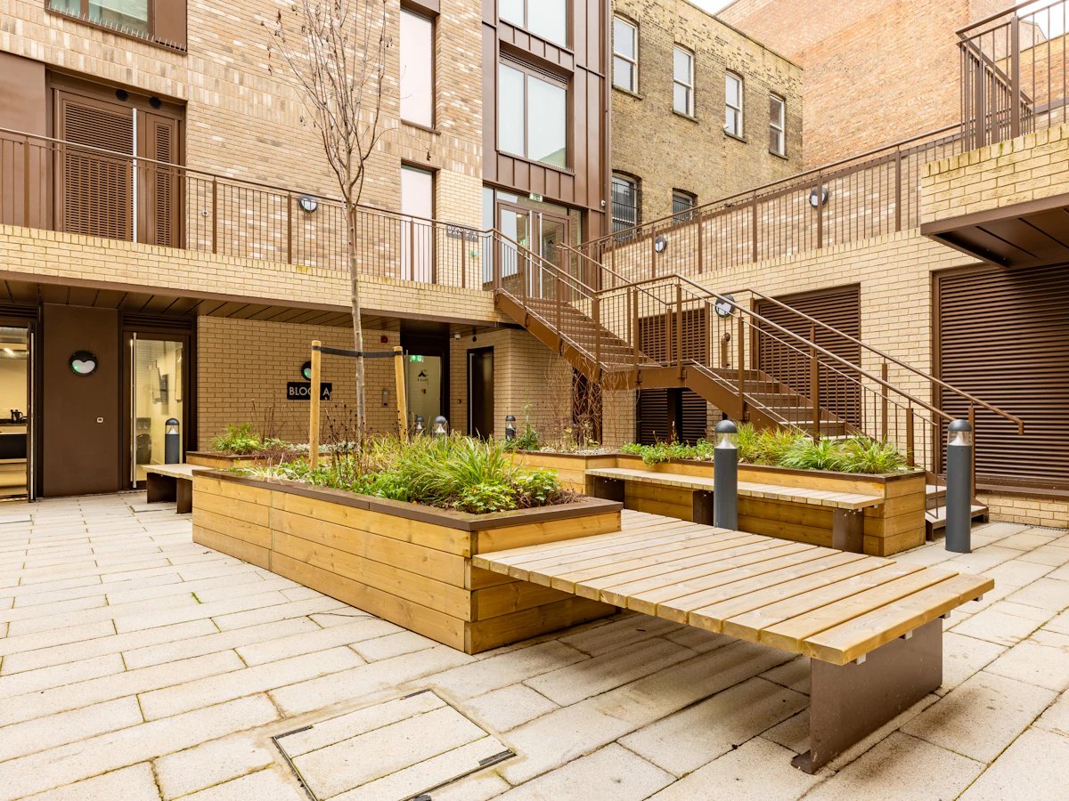 Courtyard with wooden planters benches and stairs exterior at Venue Studios in London Student Accommodation