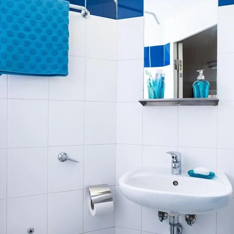 Blue towel sink soap dispenser toothbrushes bathroom at Albert Court in Liverpool Student Accommodation