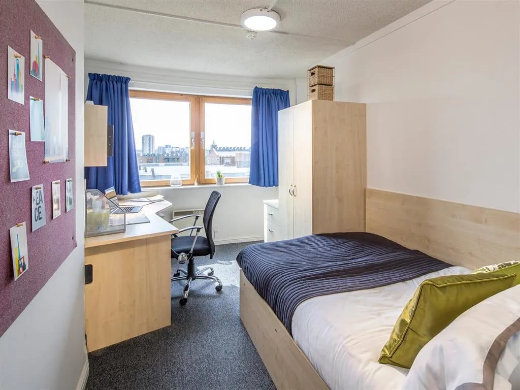 Bed desk chair wardrobe student accommodation bedroom at New Orient House in London Student Accommodation