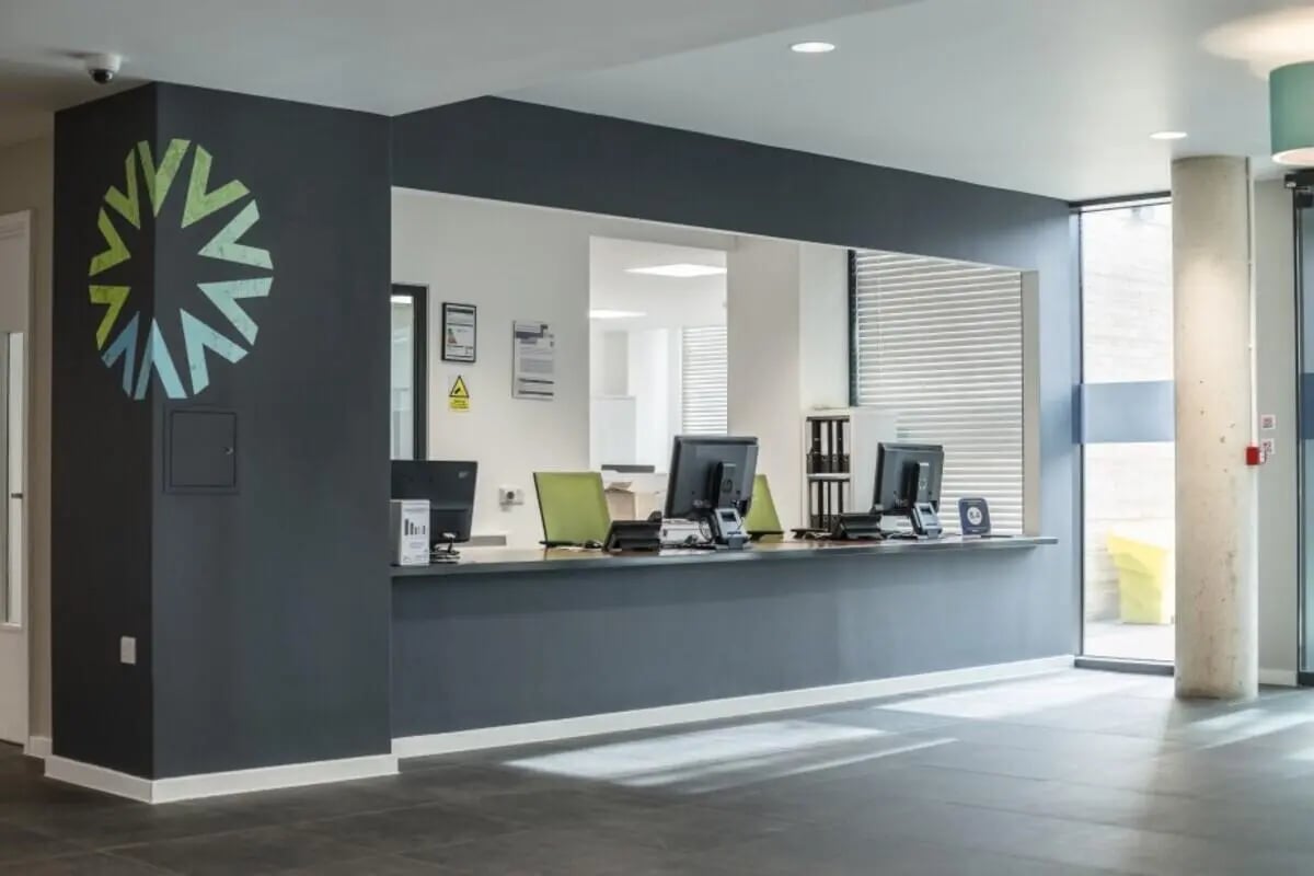 Reception desk with computers and chairs reception area at Prince Consort Village in London Student Accommodation