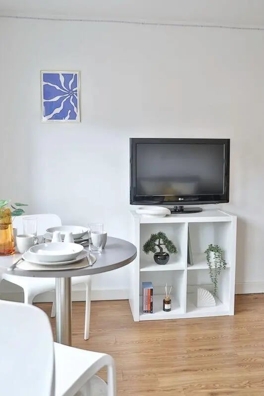 Table chairs TV and shelving unit living room at Pavilion Court in Canterbury Student Accommodation