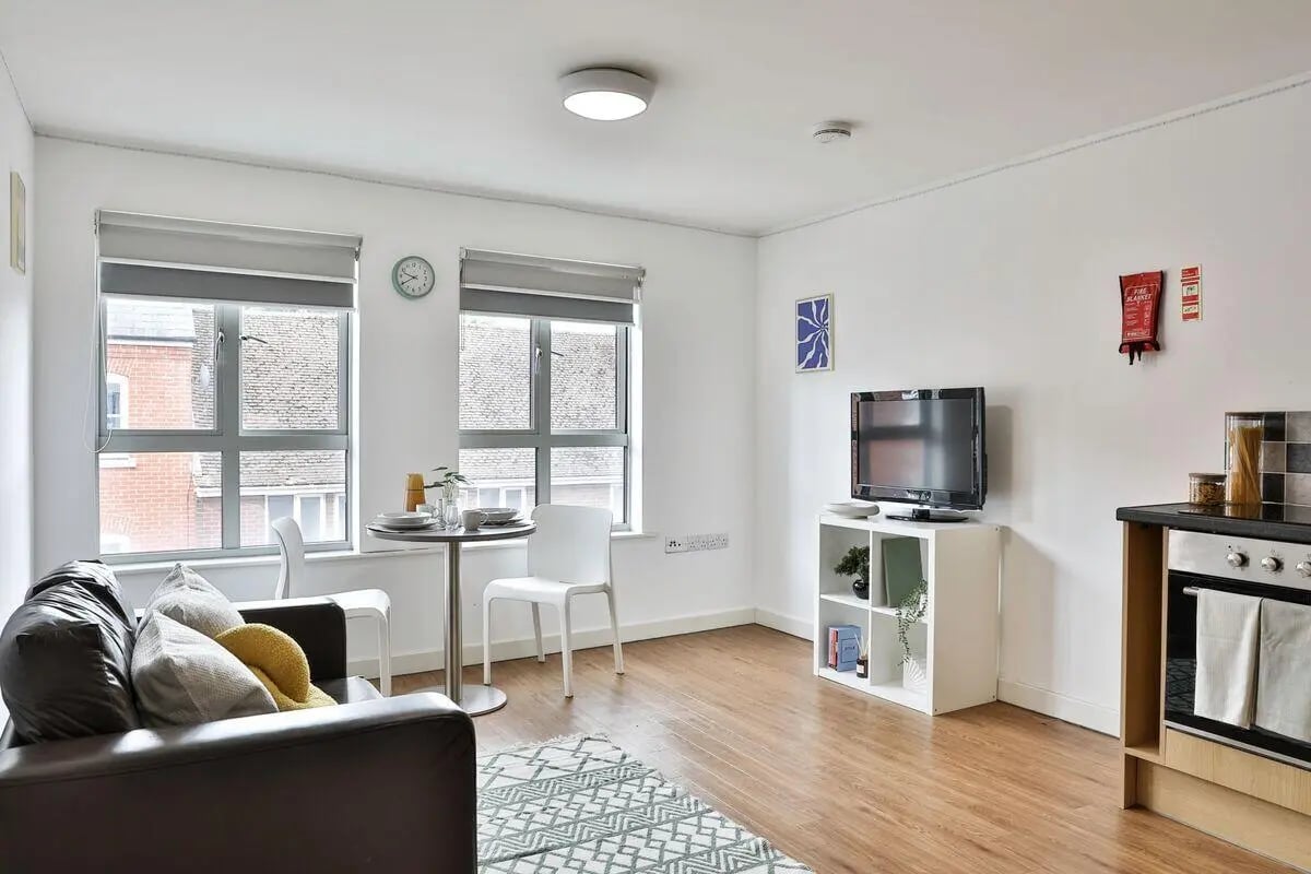 Sofa table chairs TV and kitchen living room at Pavilion Court in Canterbury Student Accommodation