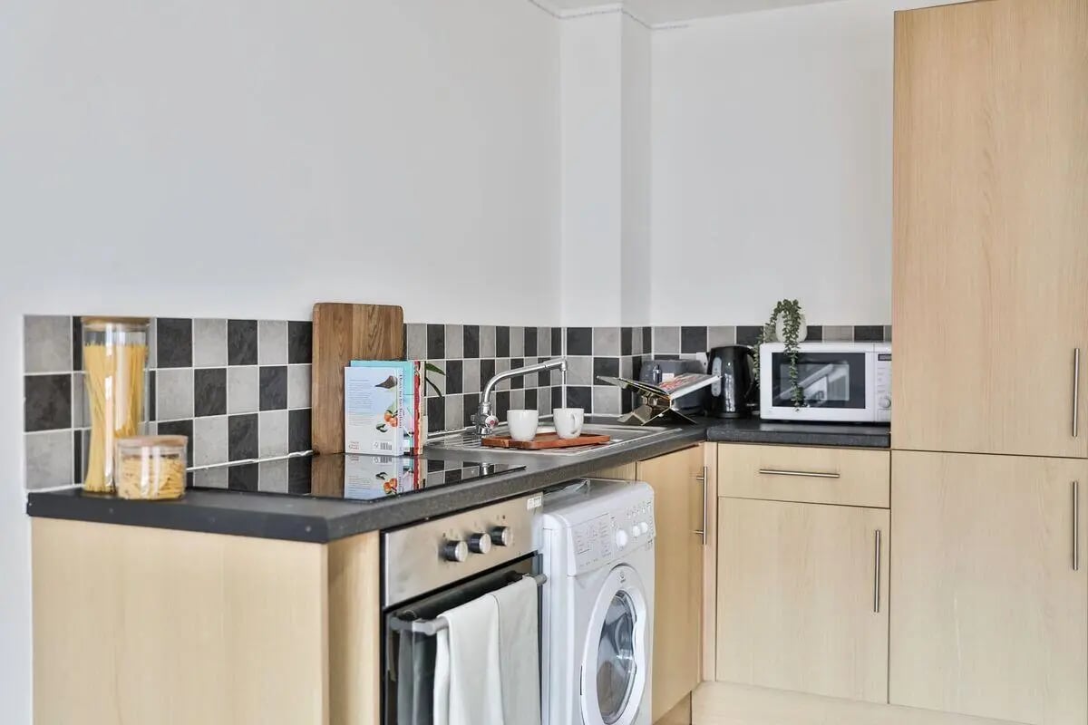 Washing machine microwave kettle sink cooking area kitchen at Pavilion Court in Canterbury Student Accommodation
