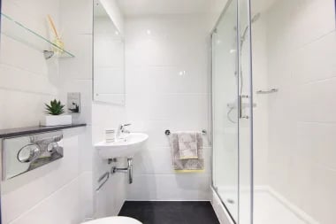 White tiled bathroom with sink shower and mirror bathroom at Glendower House in Cardiff Student Accommodation