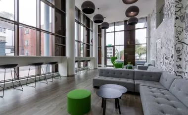 Modern lounge with sofas and bar seating living room at Glendower House in Cardiff Student Accommodation
