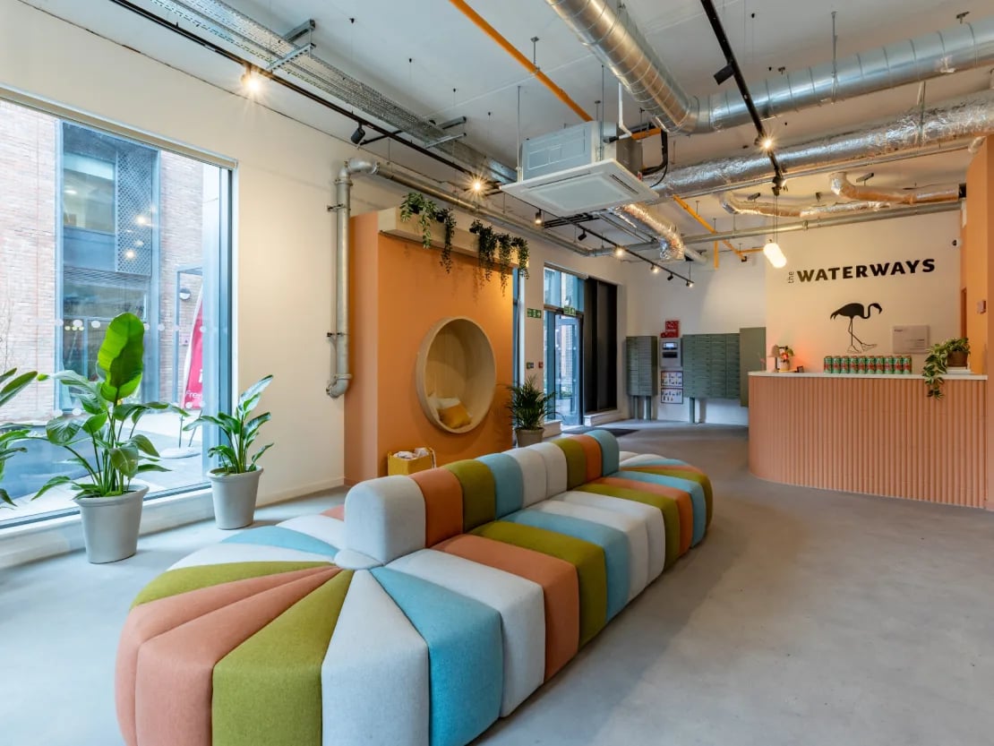 Colorful sofa plants reception desk communal area at The Waterways Nottingham in Nottingham Student Accommodation