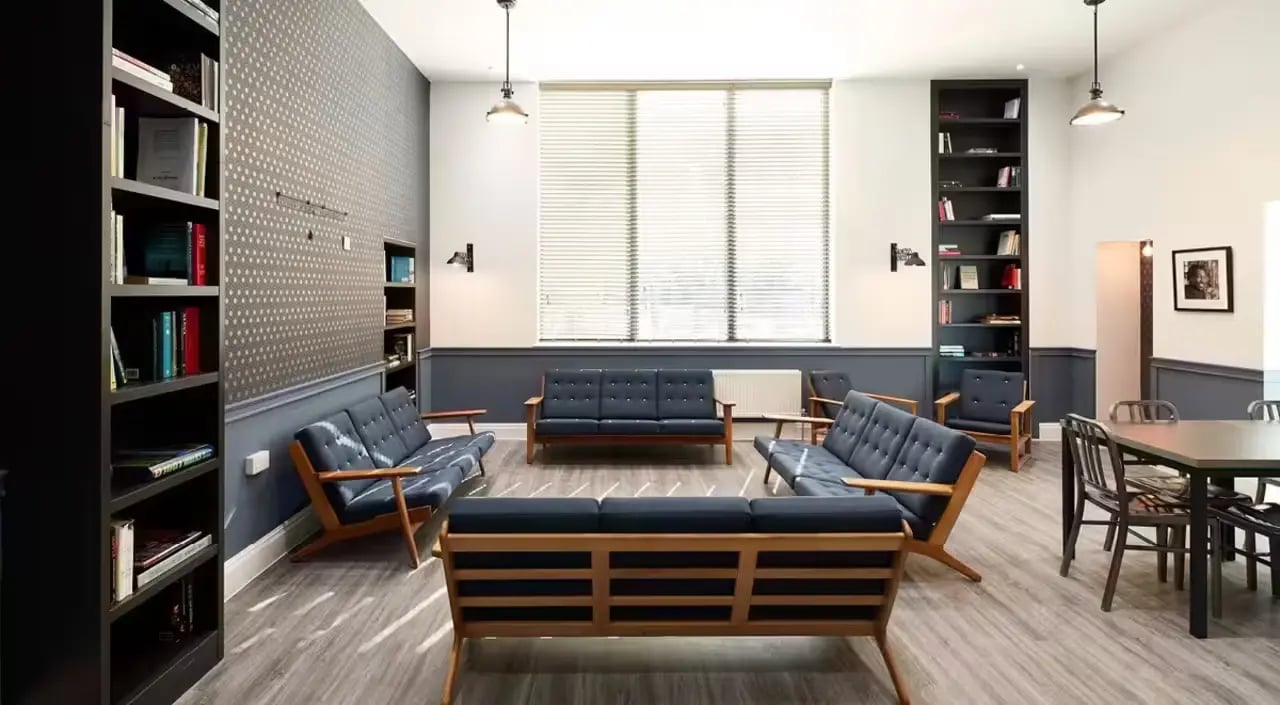 Sofas bookshelves and dining table living room at Townhall Camberwell in London Student Accommodation