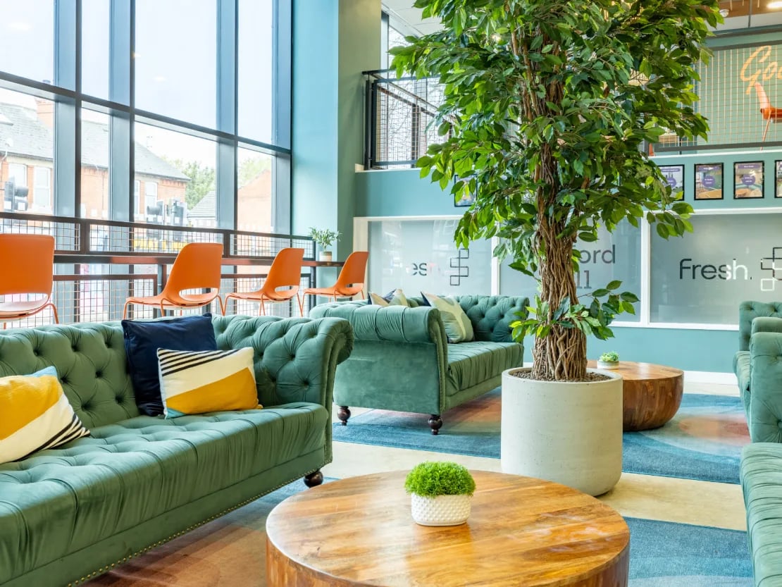 Green chesterfield sofas and orange chairs lounge area at Radford Mill in Nottingham Student Accommodation