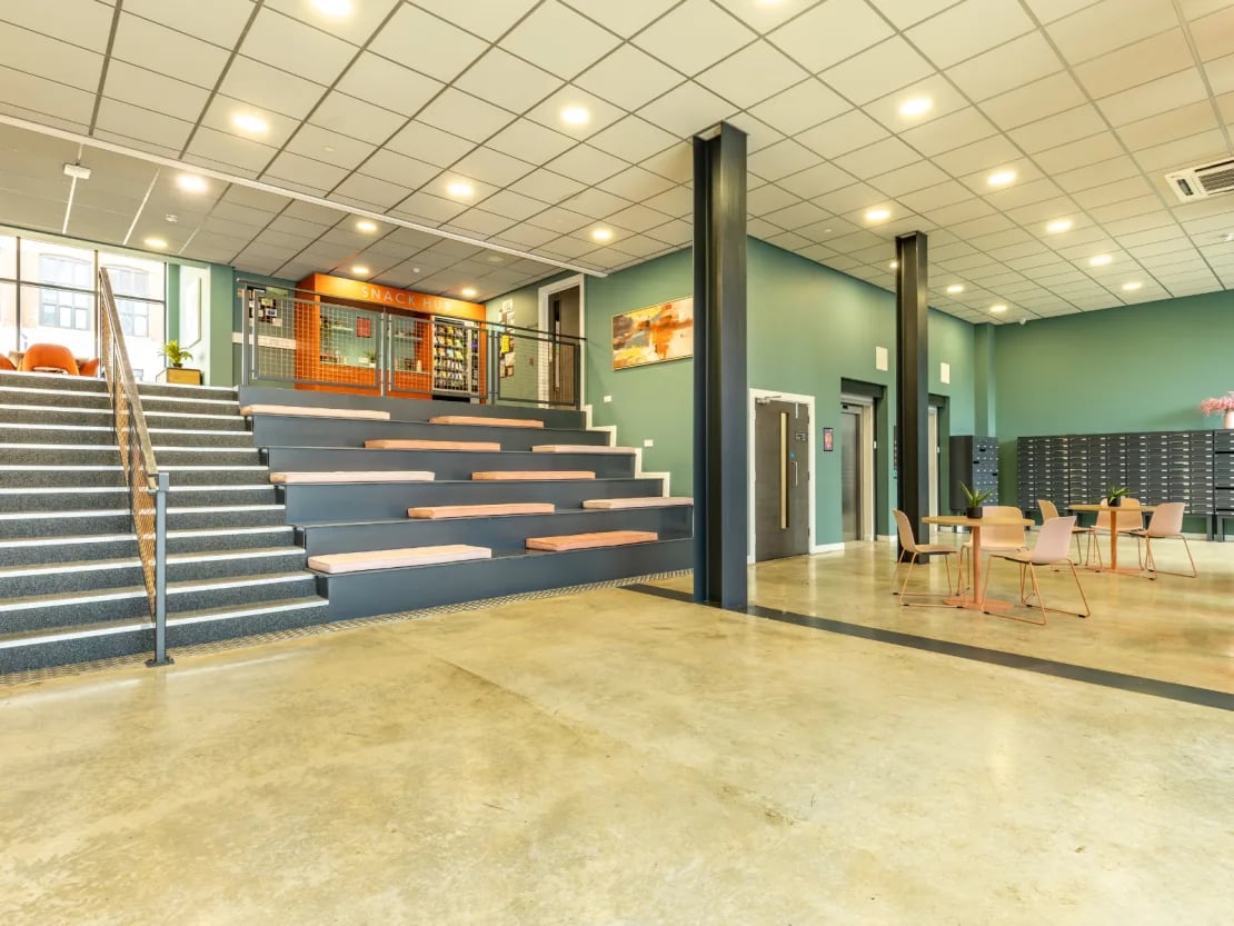 Seating area with snack machines and tables communal area at Radford Mill in Nottingham Student Accommodation