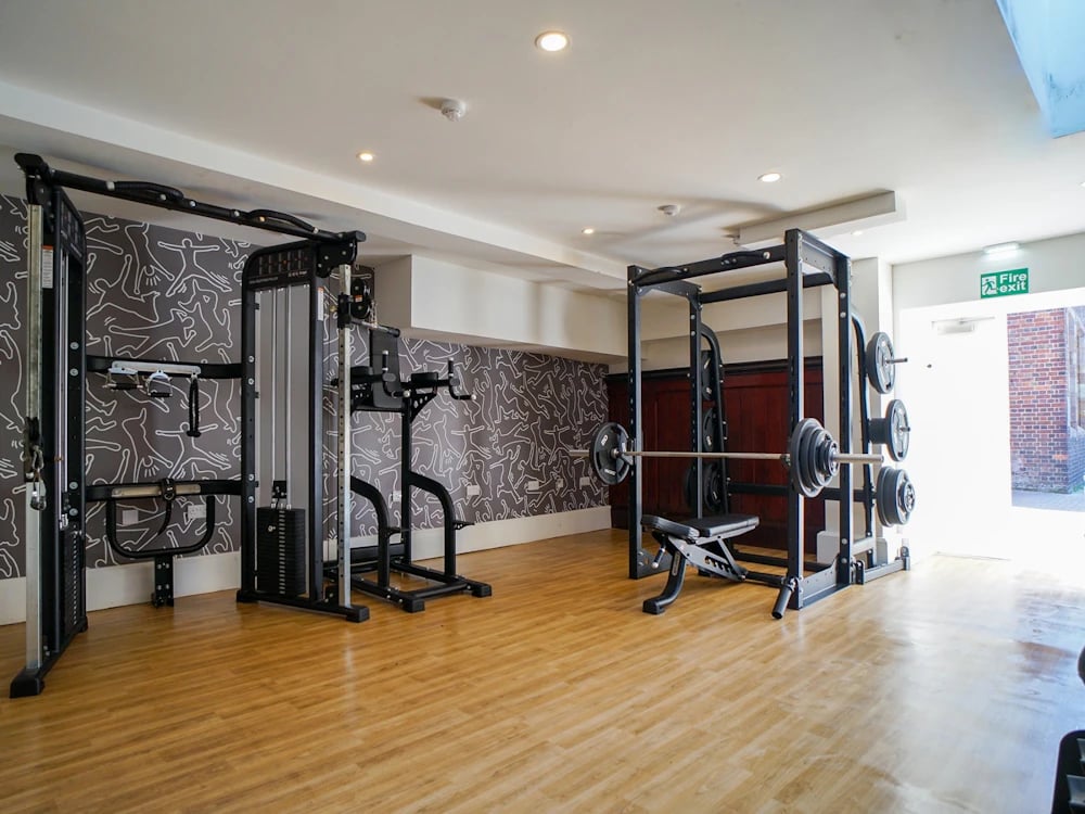 Weight machines and barbell rack gym area at Orme House in Newcastle Under Lyme Student Accommodation