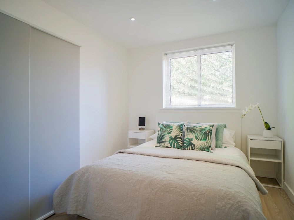 Bed with tropical pillows and bedside table bedroom at Orme House in Newcastle Under Lyme Student Accommodation