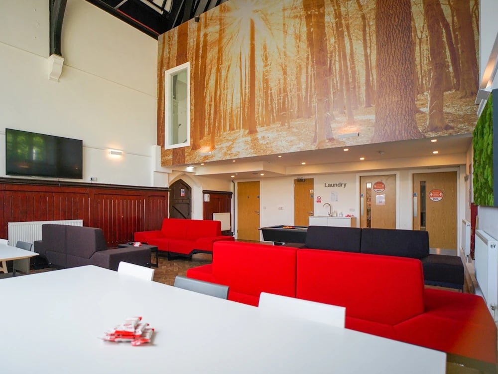 Red and black sofas pool table laundry area living room at Orme House in Newcastle Under Lyme Student Accommodation