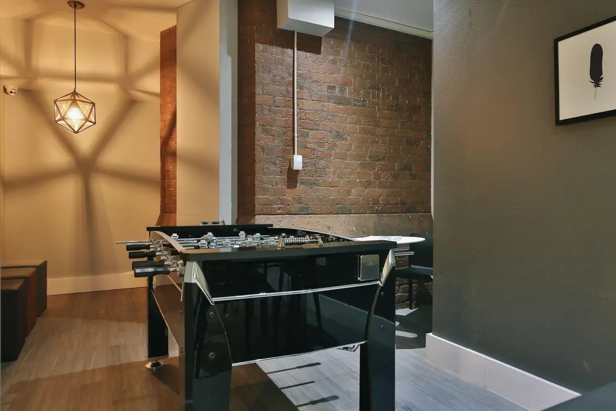 Foosball table with brick wall decor common area at The Hahnemann Building in Liverpool Student Accommodation