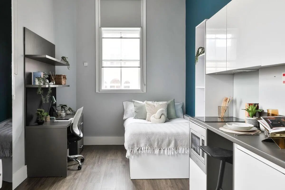 Bed desk shelves and kitchenette student studio at The Hahnemann Building in Liverpool Student Accommodation