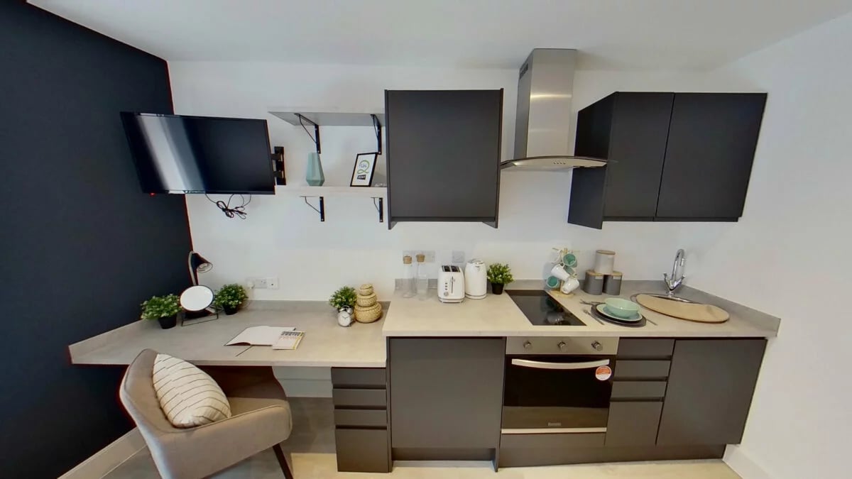 TV desk chair kitchen appliances and cabinets kitchen at Dojo House Nottingham in Nottingham Student Accommodation