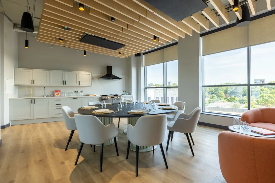 Dining table with chairs and kitchen area common room at Winfield Court in Nottingham Student Accommodation