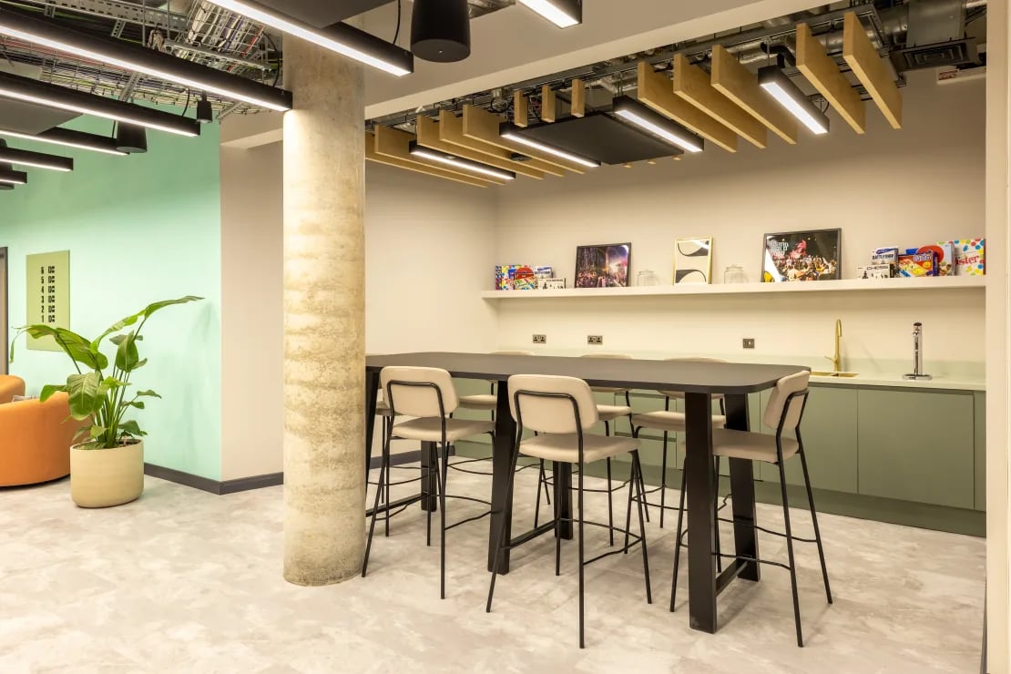 Long table and chairs with plant kitchen area at Winfield Court in Nottingham Student Accommodation