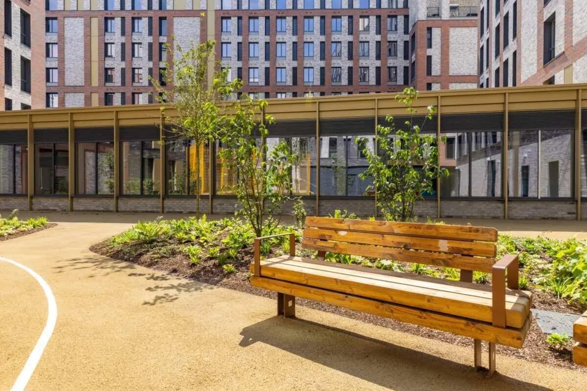 Wooden bench in a courtyard with trees exterior at Winfield Court in Nottingham Student Accommodation