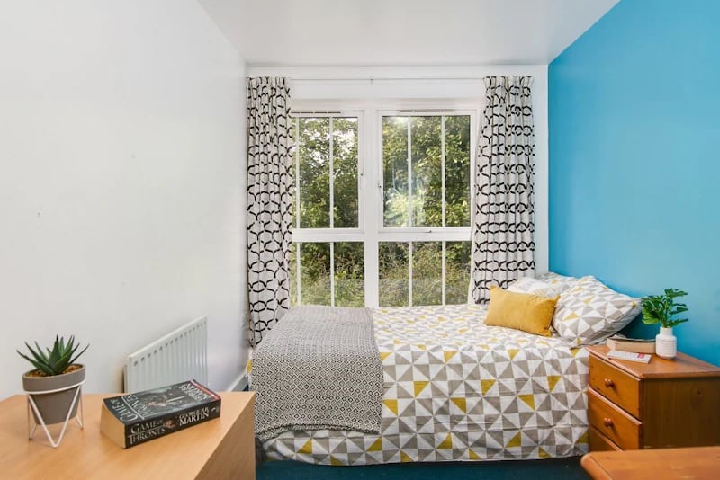 Bed with patterned bedding nightstand and window bedroom at Parham Student Village in Canterbury Student Accommodation