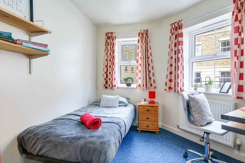 Bed shelves nightstand desk and chair bedroom at Parham Student Village in Canterbury Student Accommodation