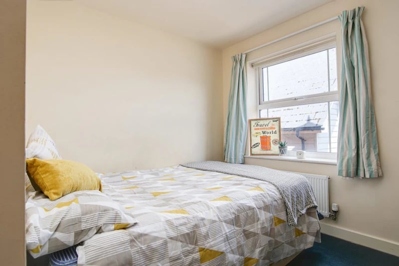 Bed with yellow pillow patterned bedding window bedroom at Parham Student Village in Canterbury Student Accommodation