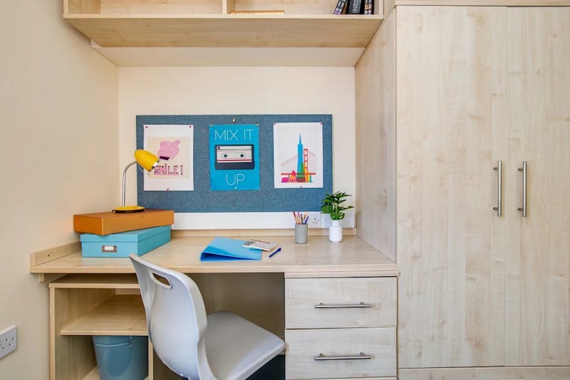Desk with lamp chair corkboard and wardrobe study area at Parham Student Village in Canterbury Student Accommodation