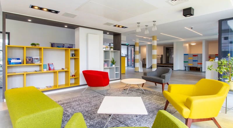 Colorful chairs yellow shelf and coffee tables lounge area at Duresme Court in Durham Student Accommodation