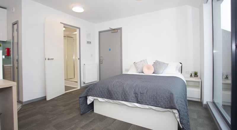 Bed with grey duvet pillows and bedside table bedroom at Duresme Court in Durham Student Accommodation