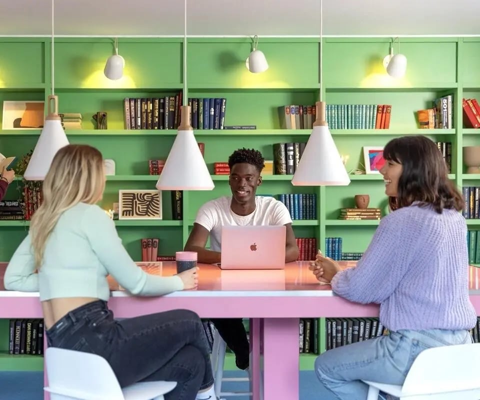 Three students at a table with laptop study area at Scape Guildford in Guildford Student Accommodation