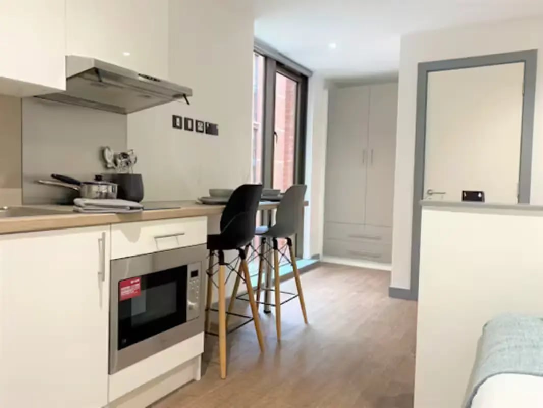 Kitchen with microwave chairs and cabinets kitchen at Great Patrick Street in Belfast Student Accommodation