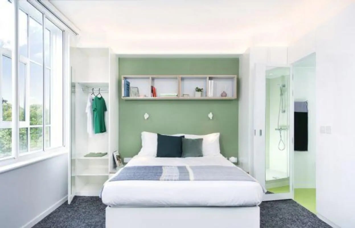 Bed with pillows wardrobe and shower bathroom bedroom at Scape Bloomsbury in London Student Accommodation