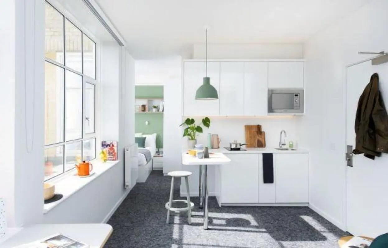 Kitchen and bed area with microwave and table Kitchen area at Scape Bloomsbury in London Student Accommodation