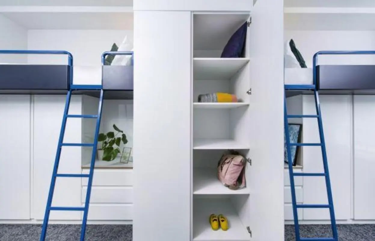 Bunk beds with blue ladders storage closet bedroom at Scape Bloomsbury in London Student Accommodation