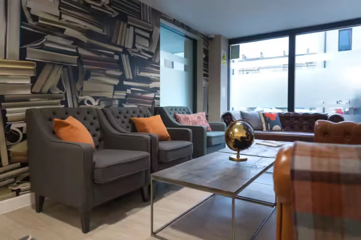 Sofas armchairs coffee table and globe living room at James House in Bath Student Accommodation