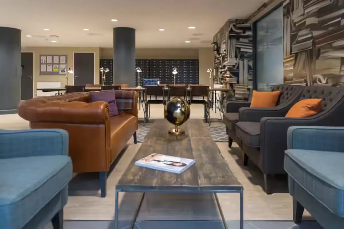 Leather couch and armchairs with globe coffee table common area at James House in Bath Student Accommodation
