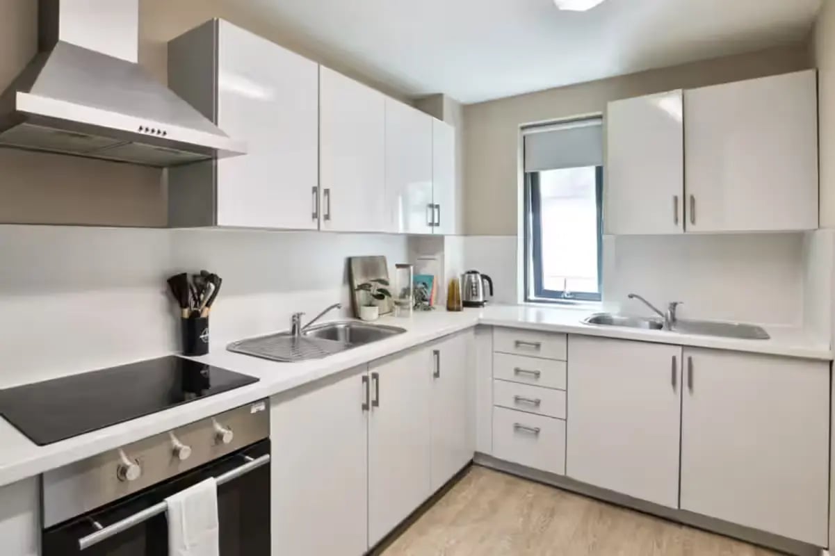 White cabinets stove sink and oven kitchen at James House in Bath Student Accommodation