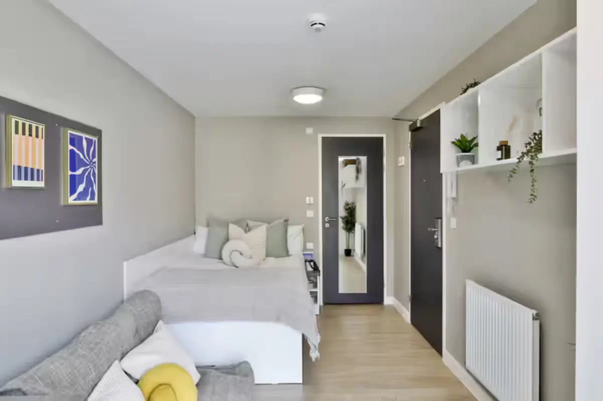 Bed sofa paintings and shelf bedroom at James House in Bath Student Accommodation