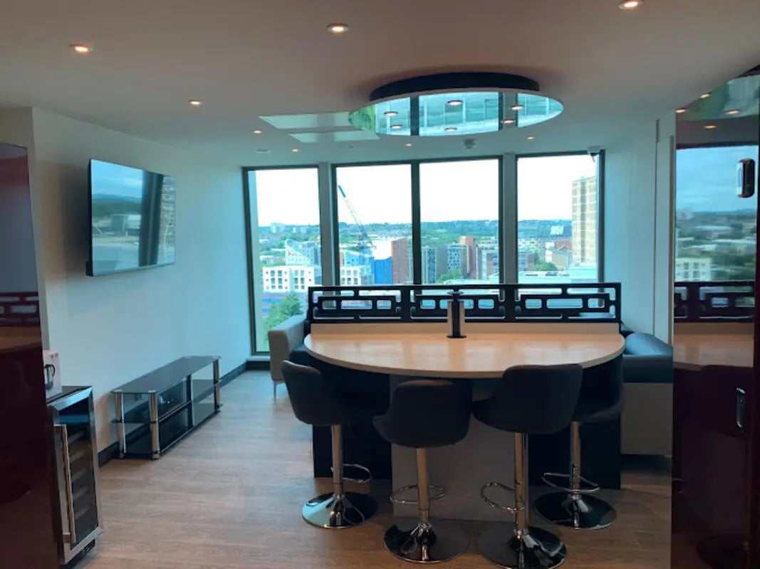 Round table with bar stools and TV lounge area at Brotherton House in Leeds Student Accommodation