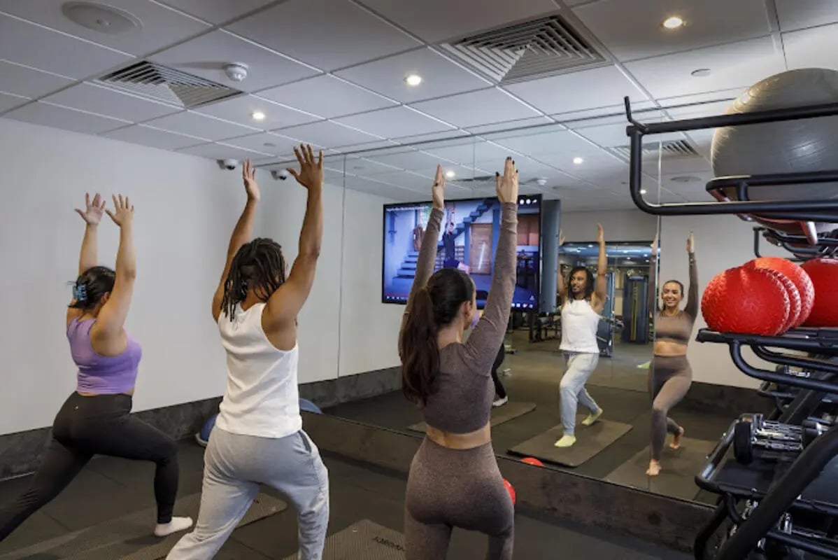 People doing yoga in gym with mirrors and equipment gym at Brotherton House in Leeds Student Accommodation
