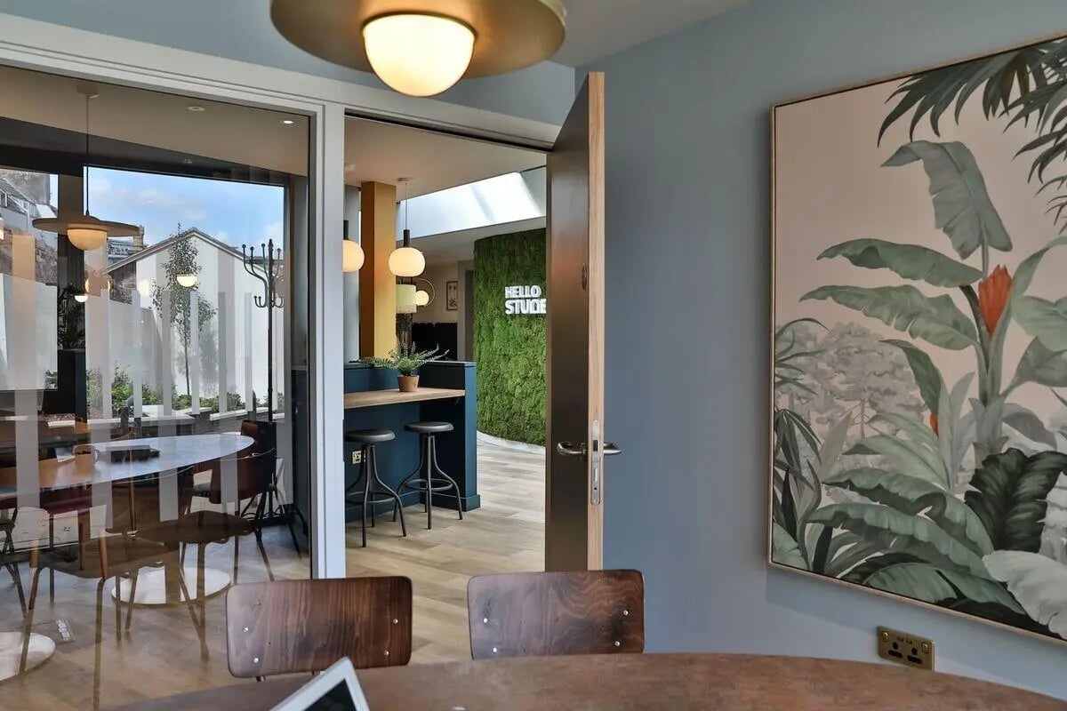 Tables chairs plant wall art common area at St Mary's in Bristol Student Accommodation