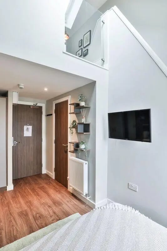 Wood floor doors shelves TV radiator bedroom at St Mary's in Bristol Student Accommodation