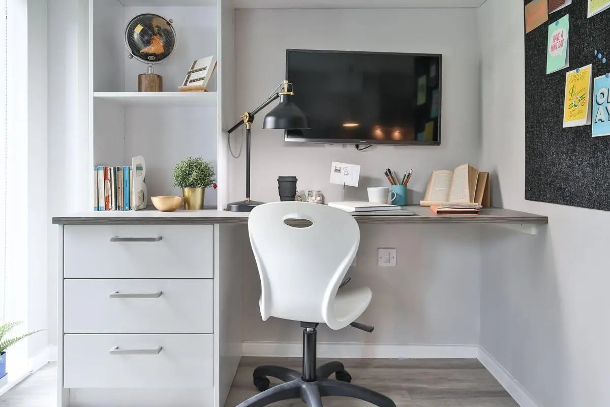 Desk with chair TV books and globe study area at William & Matthew House in Bristol Student Accommodation