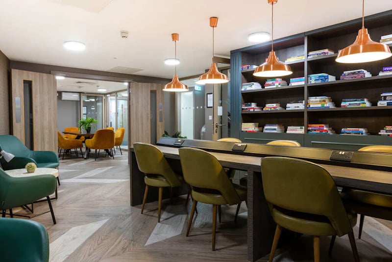 Shared study area with chairs and bookshelves. at West Gate in Exeter Student Accommodation