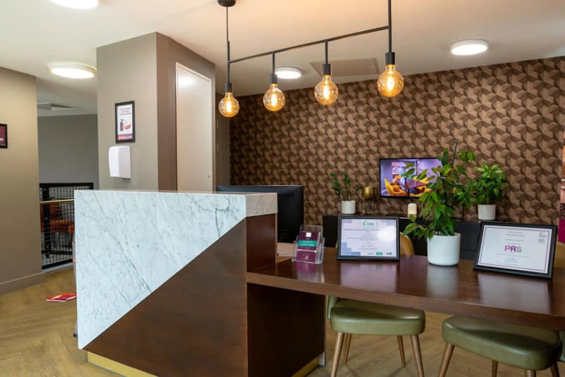 Reception desk with marble front and framed certificates lobby at West Gate in Exeter Student Accommodation