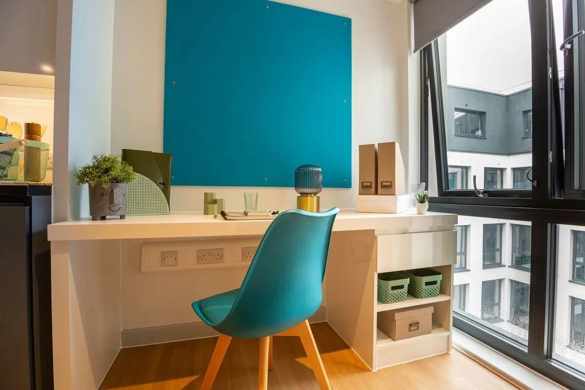Desk chair plant folders lamp and shelves study area at Market Quarter Studios in Bristol Student Accommodation