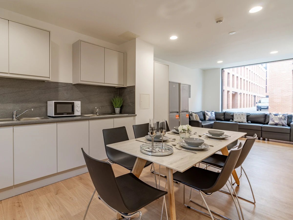 Dining table chairs kitchen living room exterior at Straits Village in Nottingham Student Accommodation