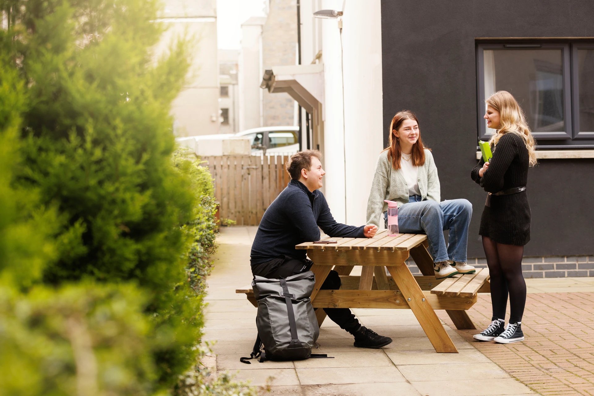 Students sitting at picnic table exterior at Spring Gardens in Aberdeen Student Accommodation