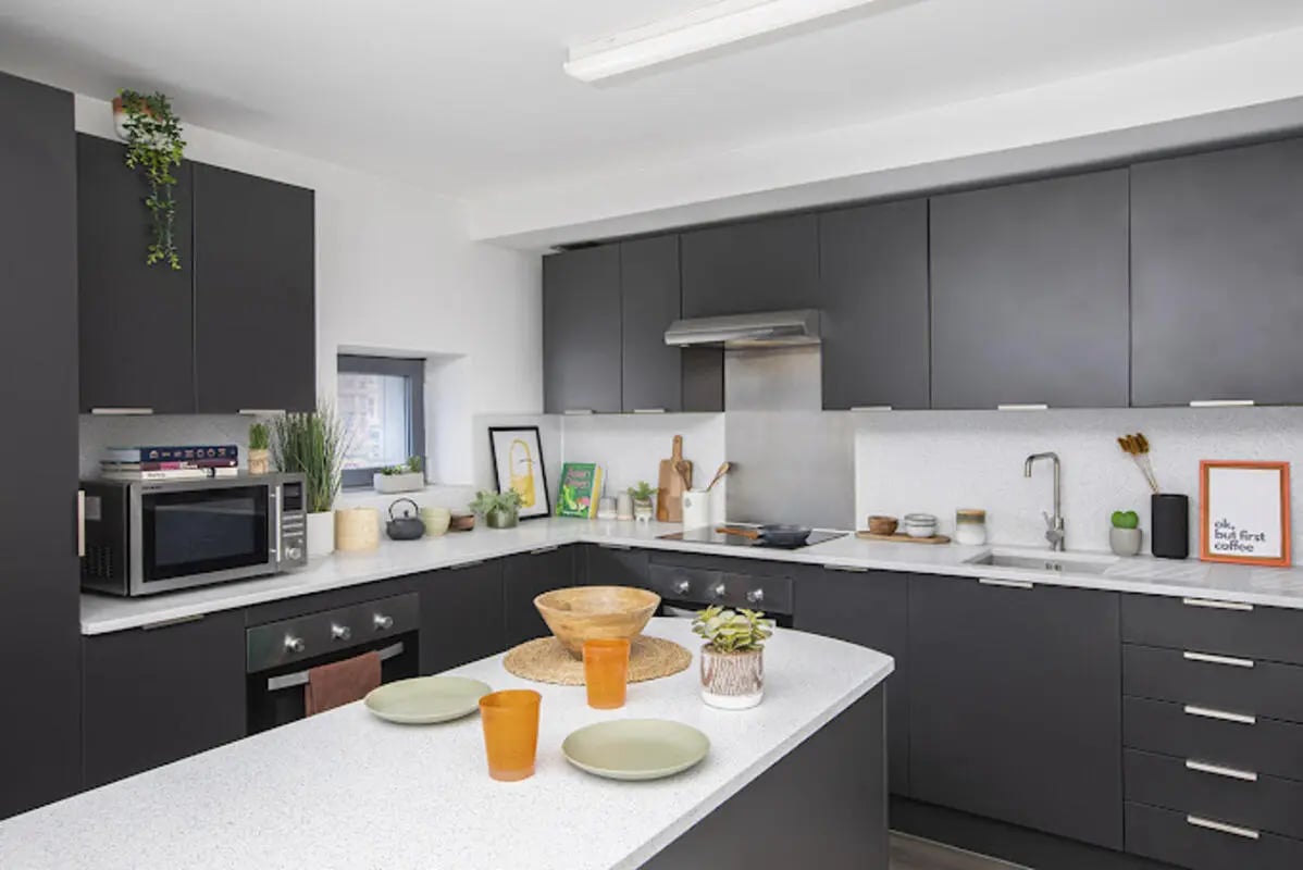 Modern dark kitchen island with plates and glasses kitchen at Lakeside in Birmingham Student Accommodation