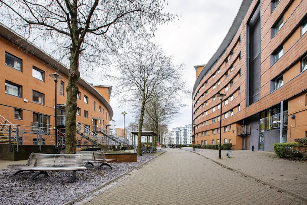 Orange buildings with benches and trees exterior at Lakeside in Birmingham Student Accommodation