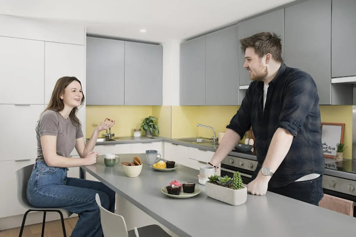 Couple talking in modern kitchen with cupcakes kitchen at Staniforth House in Birmingham Student Accommodation